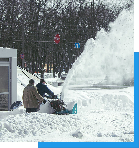Commercial Snow Removal & Ice Control 2 Workers operating a walk-behind snowblower clearing deep snow in a parking lot