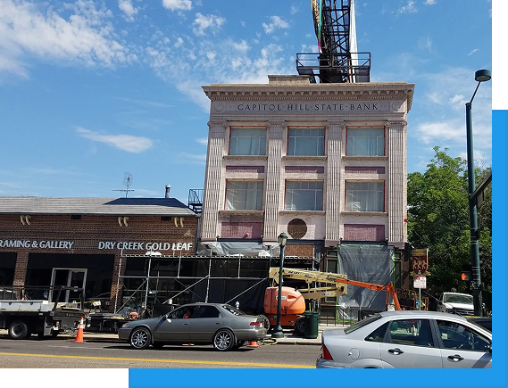 About us 5 Capitol Hill State Bank historic building on a commercial street with scaffolding and construction equipment during exterior restoration