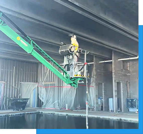 About us 3 Worker elevated on a green boom lift inside a large industrial building performing overhead ceiling work